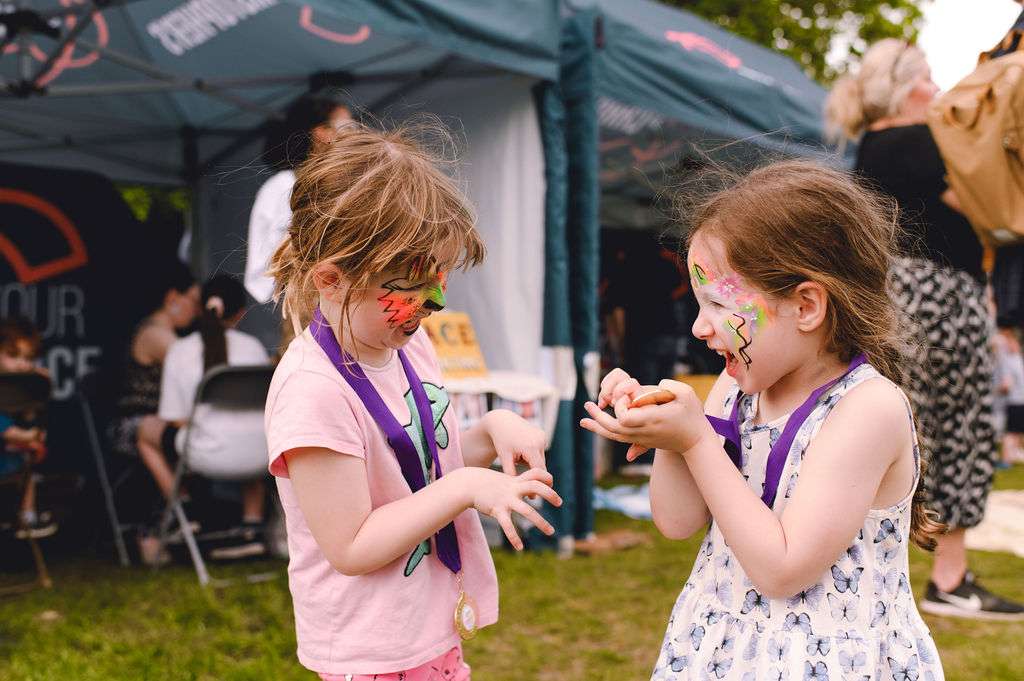 Two young children showing their face paint